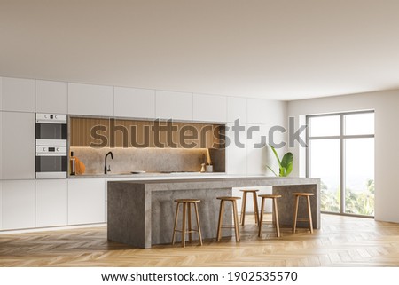 Corner of modern kitchen with white walls, wooden floor, bar counter and two ovens. Window with blurry view. 3d rendering