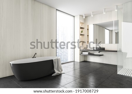 Black and wooden white minimalist bathroom with sink and mirror, black bathtub near window, side view. Modern minimalist bathroom on black tiled floor, 3D rendering no people