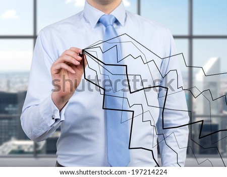 Businessman drawing line graphs