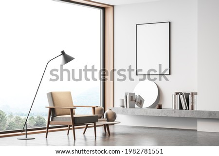 White room interior with beige armchair, lamp with coffee table on concrete floor, panoramic window with view on countryside. Copy space blank frame, art books and decoration, 3D rendering