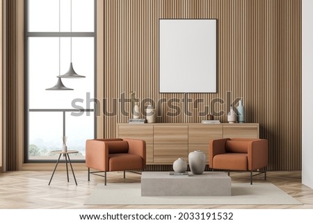 Two orange armchairs and a poster for the modern living room interior design, using wood wall panelling. A sideboard, pendant lamps, coffee tables, a window and parquet. Mockup. 3d rendering