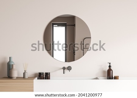 Modern vanity design, using wood-look material pairing with white ceramic sinks and a stylish round mirror on the beige wall of the shower room. A concept of interior trends. 3d rendering