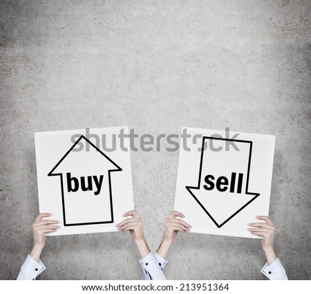Hands holding two banners - the choice of choice \'sell or buy\'.