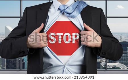 A concept of preventing risks. Businessman tears the shirt with the stop sign on the chest.