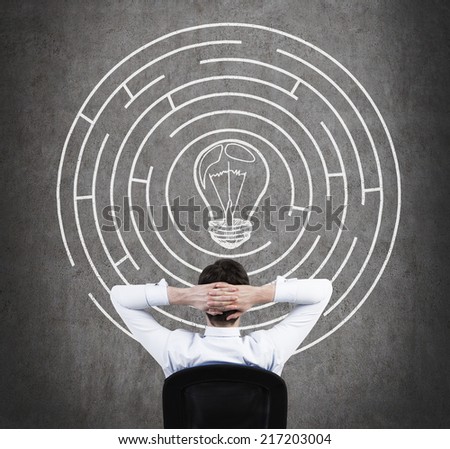 Relaxed businessman brainstorming the labyrinth to find an exceptional business idea.