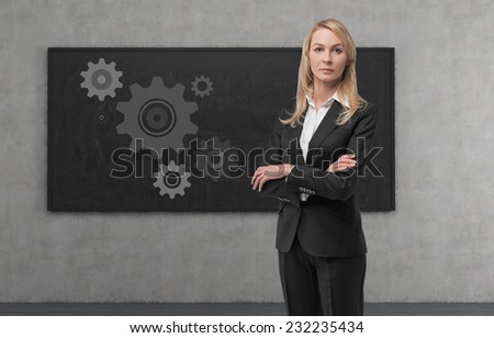 Thinking blonde business woman with gears - A concept of well organized work process.