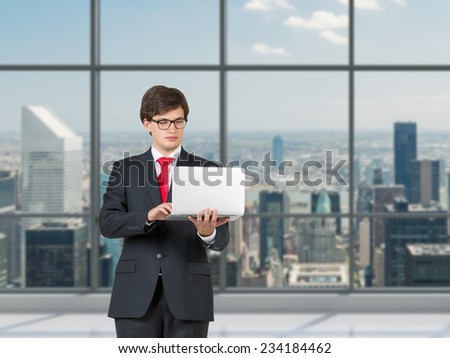 Businessman is searching for information using a personal computer, modern office background.