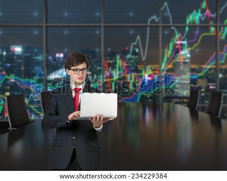 Working businessman in the office. Forex graph and an amazing night view of the business city area. A metaphor of international financial consulting.