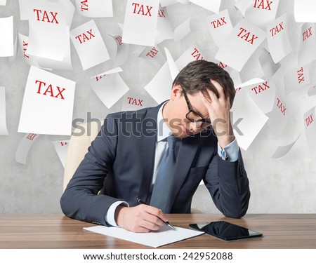 young businessman working and falling tax papers
