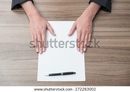 Close up of businesswoman\'s hands on the desk with the blank paper. Legal contract negotiation.