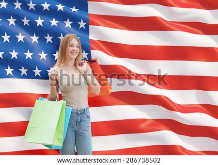 A happy young woman with the colourful shopping bags from the fancy shops. US flag background.