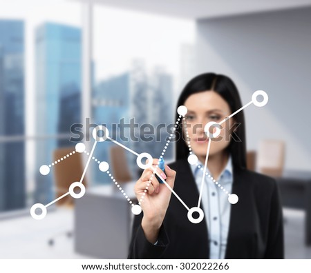 A business lady is drawing fluctuation of the financial chart on the glass screen. Office view with Singapore view in blur on the background.