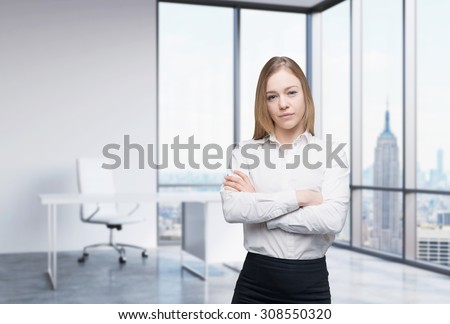 A beautiful business woman in a workplace at modern panoramic office in New York, Manhattan. A concept of financial consulting services.