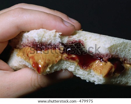 child\'s hand holding peanut butter & jelly sandwich