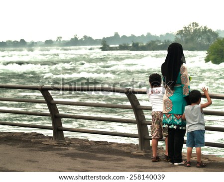 Niagara Falls, New York, USA. March, 2014. Mother and sons watching the rapids of Niagara Falls