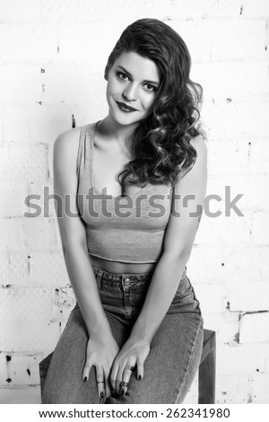 Black and white portrait of a beautiful girl. White brick wall not isolated