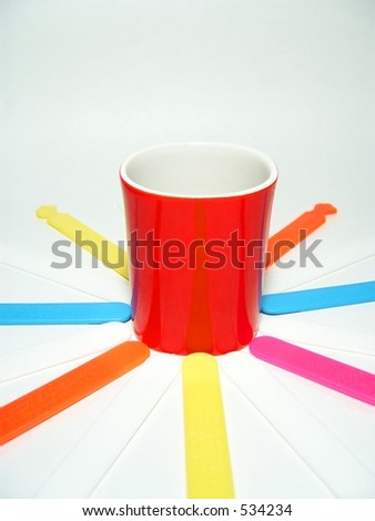 tongue depressors in different color next to a red cup for childrens