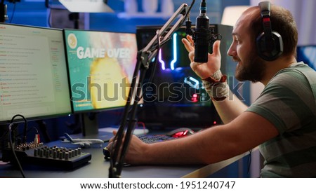 Nevous streamer losing videogame, game over for man cyber playing online space shooter games with headset. Player performing on powerful computer talking with players on chat in gaming competition