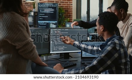 Software developers discussing about source code compiling discovers errors and asks the rest of the team for explanations in front of multiple screens running algorithms. Programmers doing teamwork. Foto stock © 