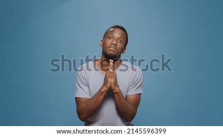 Hopeful man doign prayer gesture with hands in front of camera, begging and imploring for trust and fortune. Wishful person praying and asking for forgiveness, please and apologize pose. Imagine de stoc © 
