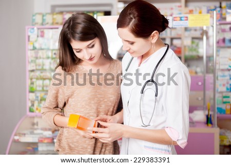 Pharmacist woman showing product to custumer interior of real pharmacy. Customer care. Healthcare business