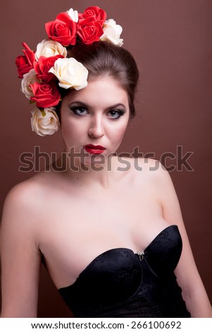 Girl with flowers in her head on brown background. Studio shooting. Spring theme. Beauty and fashion. Portrait
