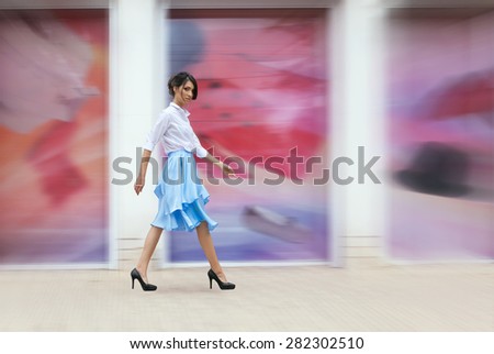 Gorgeous woman in blue skirt outside walking in the city. Fashion concept. Beauty and fashion. Style and sensuality