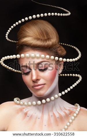 Surreal art concept of girl with pearls arround her. Studio shooting. Surrealism and concept art