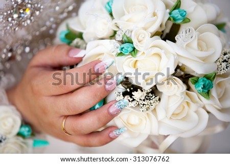 Bride with her nail done and the wedding flowers hold in her hand