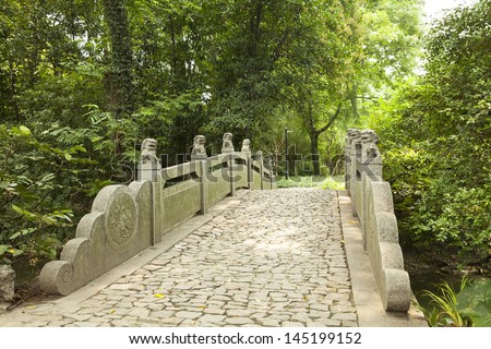 Stone bridge with stone lions in China garden, traditional culture.