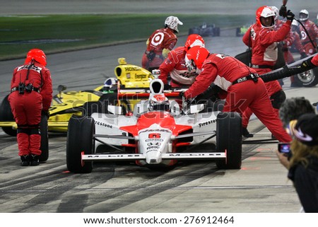 Joliet Illinois, USA - August 29, 2009: IndyCar Racing League. Pit stop. Ryan Brisco driver, Penske racing team. Team changes tires and fuels the car. Chicagoland speedway. Night Racing under lights.