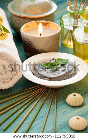 Spa still life with organic scrub, essence oil bottle, bottle of fragrance reeds diffuser, candle and incense.