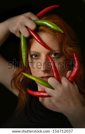 Pretty red-haired woman with Chili claws, Portrait, Studio Shot