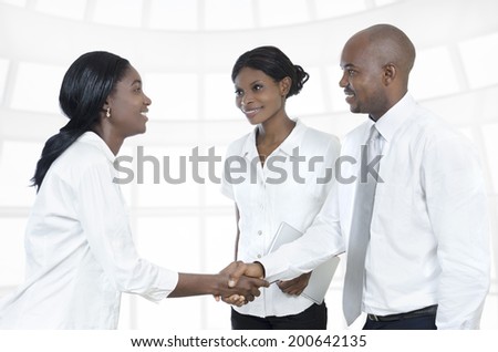 Three african business partners shake hands, Studio Shot