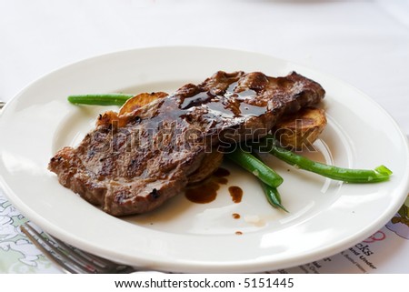 A child's steak main course meal at a fancy restaurant.