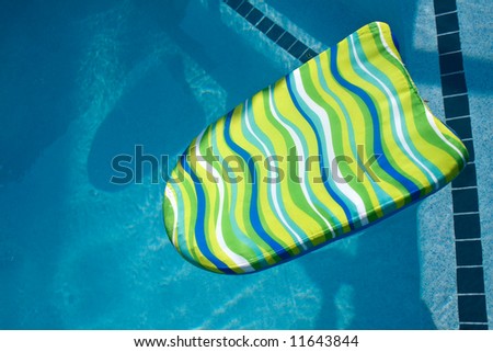 A colorful boogie board in swimming pool. Plenty of Copy Space.