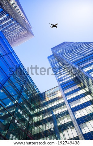 A jet airplane silhouette with business office towers background
