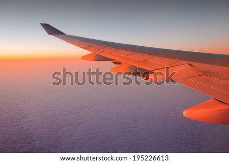 Airplane Wing in Flight from window with sunset sky