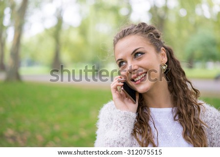 Young woman using tablet & mobile phone in the park
