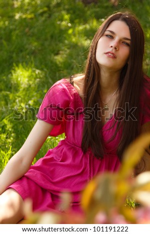 Smiling beautiful teen girl relax on spring green grass