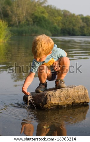 kid play with water on the river