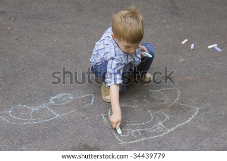 child drawing on asphalt car
