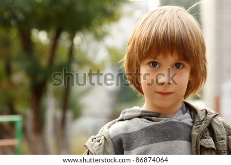 outdoor casual portrait of little cute blond caucasian boy five years old