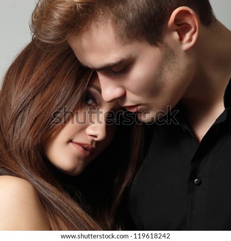 Sexy passion couple, beautiful young man and woman closeup, studio shot over black