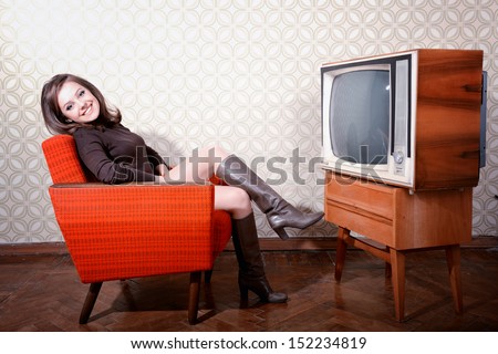 portrait of young smiling woman sitting in vintage room and watching tv, retro stylization, toned