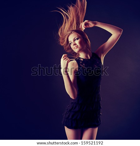 Dancing party girl. Young beautiful excited woman listening music and dancing with long blond hair fly-away, toned