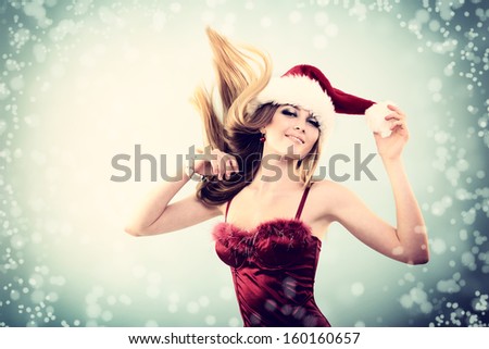 Beautiful cheerful fashion christmas girl dancing in party in Santa\'s hat in snow, toned