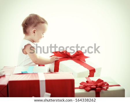 Holidays, baby girl opening box with presents, christmas, birthday, new year, x-mas concept - happy child girl with gift boxes, toned