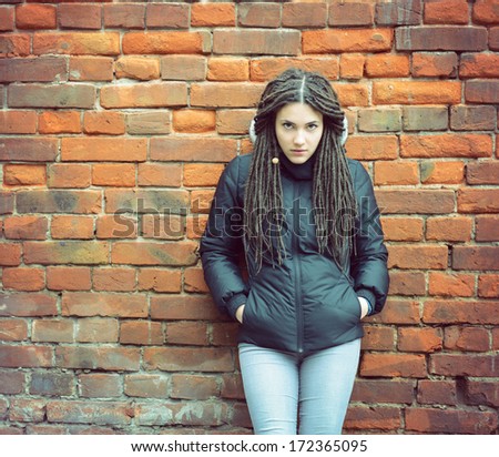 Portrait of beautiful cool girl over grunge wall