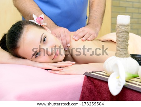 Beautiful woman enjoy having relaxing massage her back in spa salon, caucasian beauty model